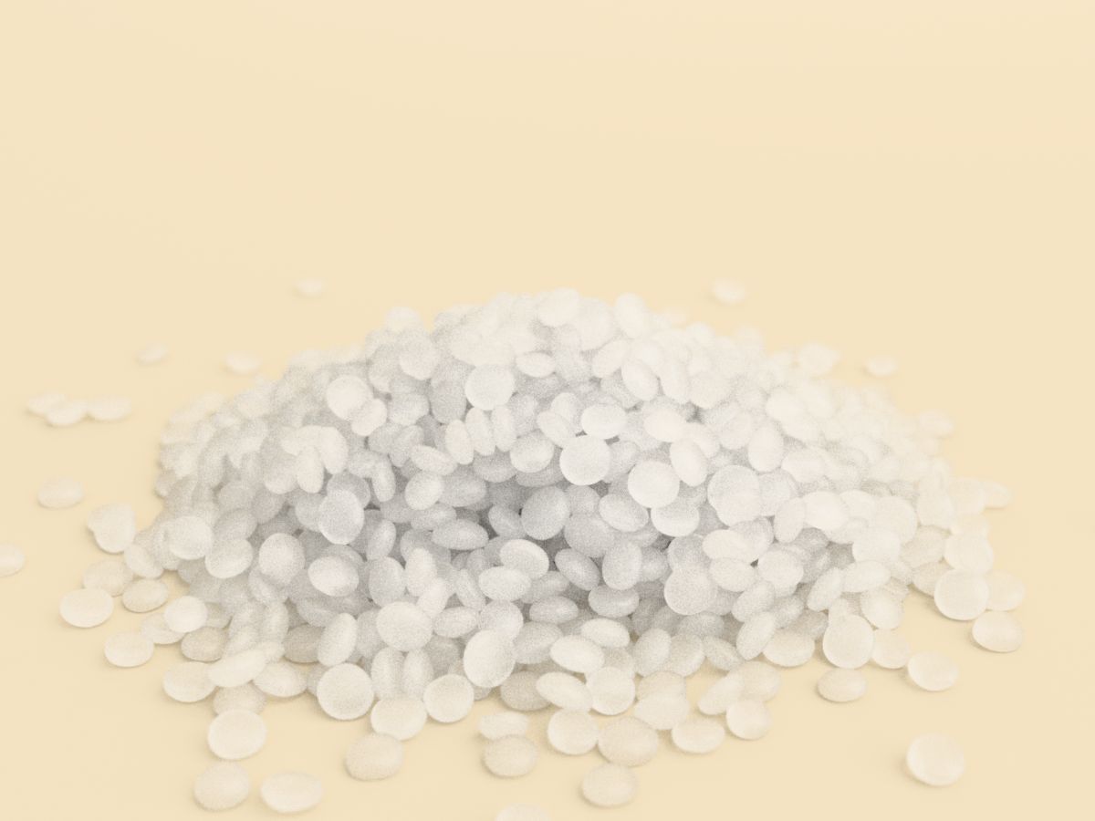 A heap of translucent, lens-shaped LDPE granules on a warm cream surface